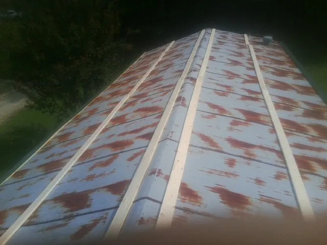Rusted metal roof panels with new wood purlins before replacement — Storm Damage Roof Repair in Morris Chapel by Roofing Brothers