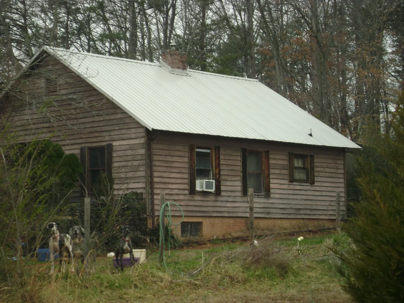 White metal roof on an old wood sided farmhouse, from a Metal Roof Installation job in Morris Chapel